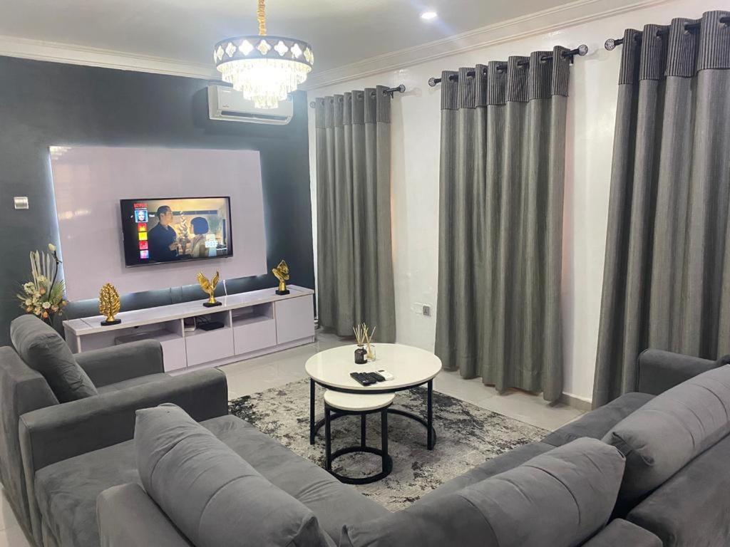 ein Wohnzimmer mit einem Sofa und einem Tisch in der Unterkunft Keduu beautiful luxury apartment lekki in Lagos