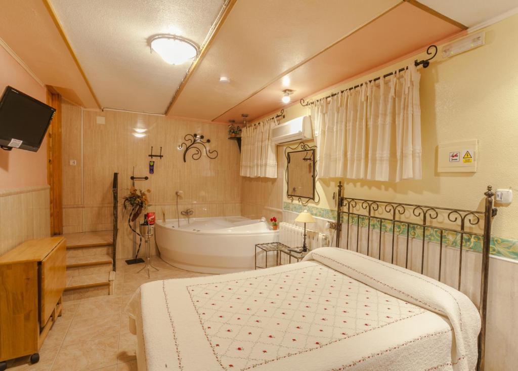 a bedroom with a bed and a tub and a sink at Pension San Jose in Bullas