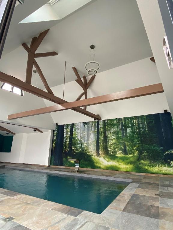 a swimming pool in a house with a large window at A la ferme in Kurtzenhouse