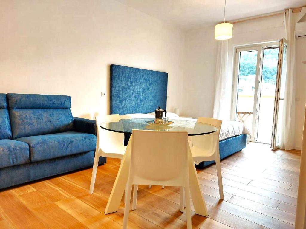 - un salon avec une table et un canapé bleu dans l'établissement Le perle della Costiera, à Sorrente