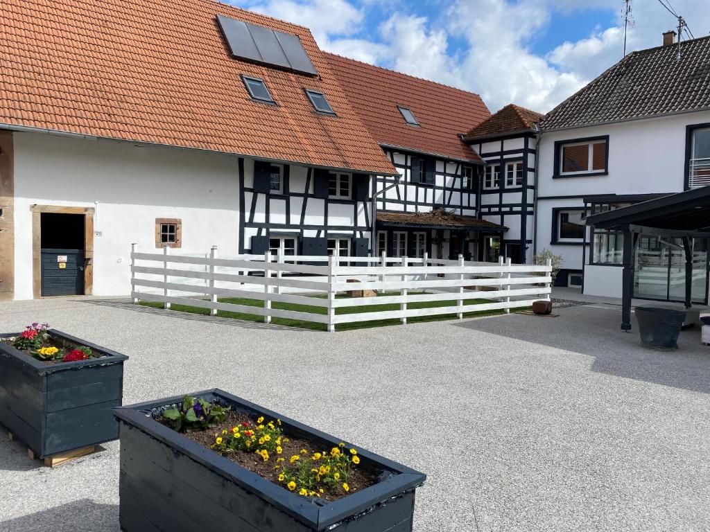 a courtyard with flowers inpots in front of a building at A la ferme in Kurtzenhouse