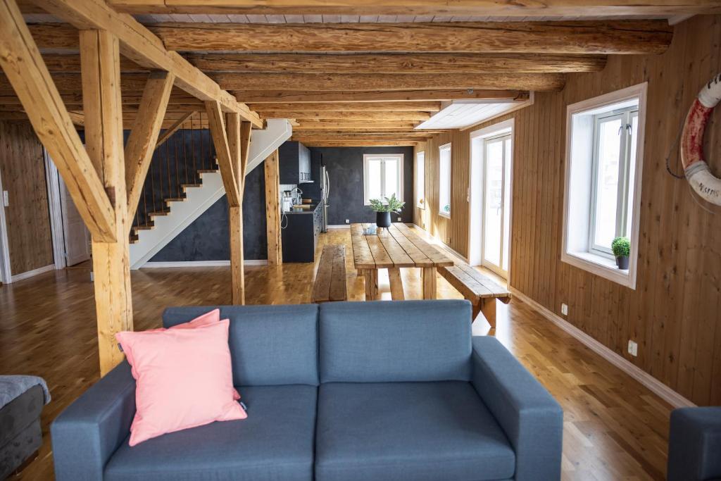 un soggiorno con divano blu e pareti in legno di The Tide - Rorbuer a Sørvågen