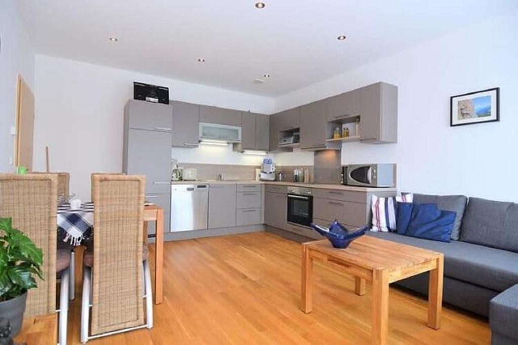 a living room with a couch and a table and a kitchen at Ferienwohnung "Ausblick" in Rötz