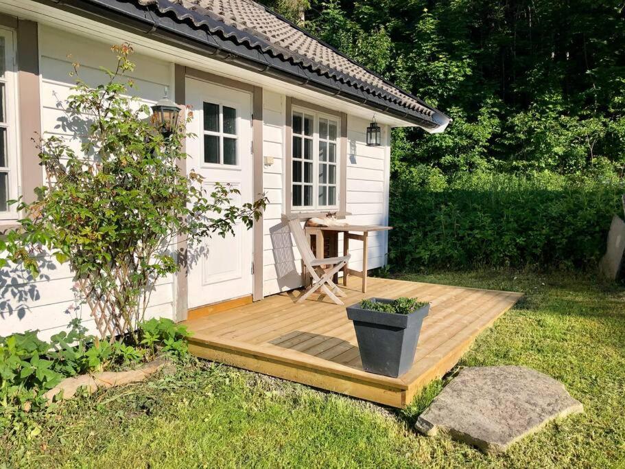 una terraza de madera con una mesa frente a una casa en Idyllic small farm appartment, en Tønsberg
