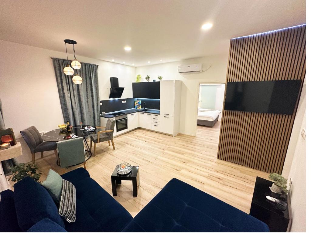 a living room with a blue couch and a flat screen tv at V Apartment Šibenik in Šibenik