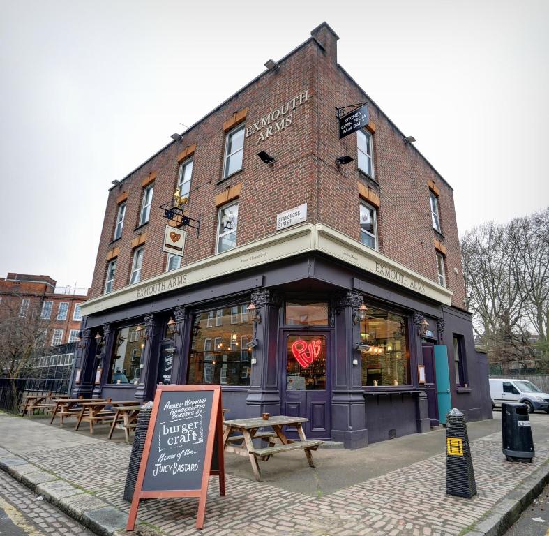 un edificio de ladrillo con un cartel delante en PubLove @ The Exmouth Arms, Euston, en Londres