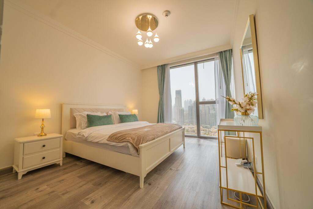 um quarto com uma cama e uma grande janela em FIRST CLASS 2BR with full BURJ KHALIFA and FOUNTAIN VIEW em Dubai