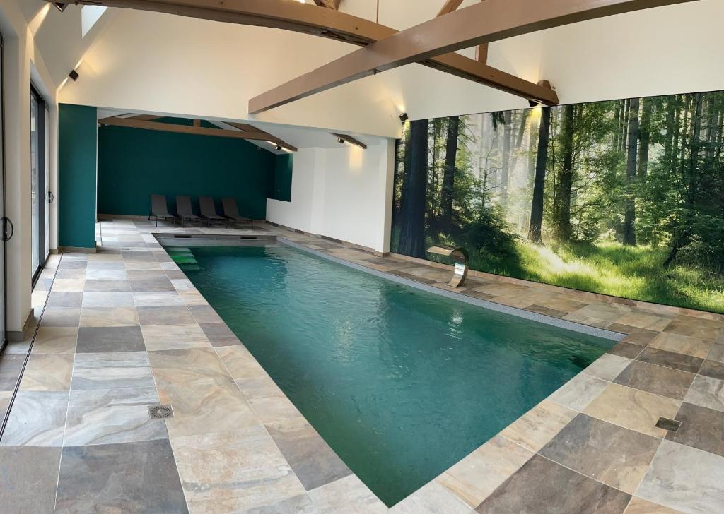 een binnenzwembad met een tegelvloer en groene muren bij A la ferme in Kurtzenhouse