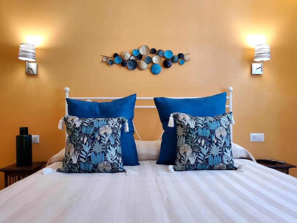 a bedroom with a bed with blue pillows at Residenza FillAnfi in Lucca