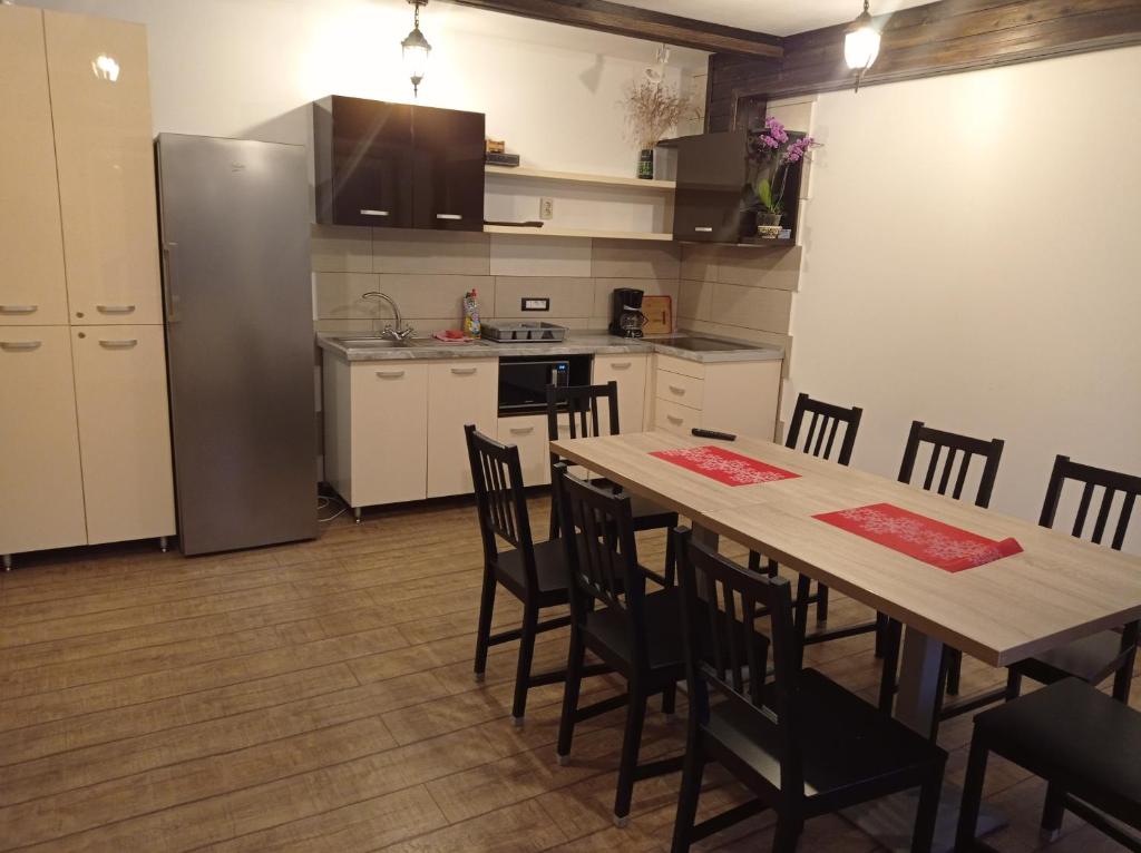 una cucina con tavolo, sedie e frigorifero di Casa Anda ad Azuga