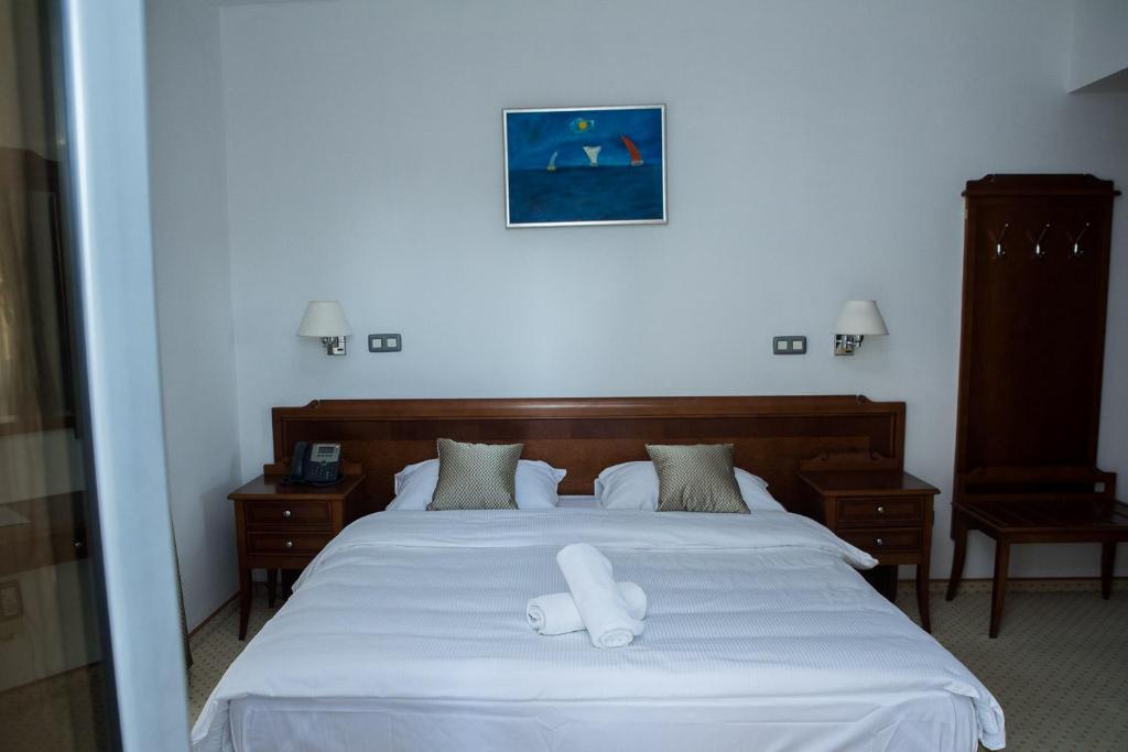 een slaapkamer met een bed met twee witte handdoeken erop bij Hotel Hum in Ljubuški