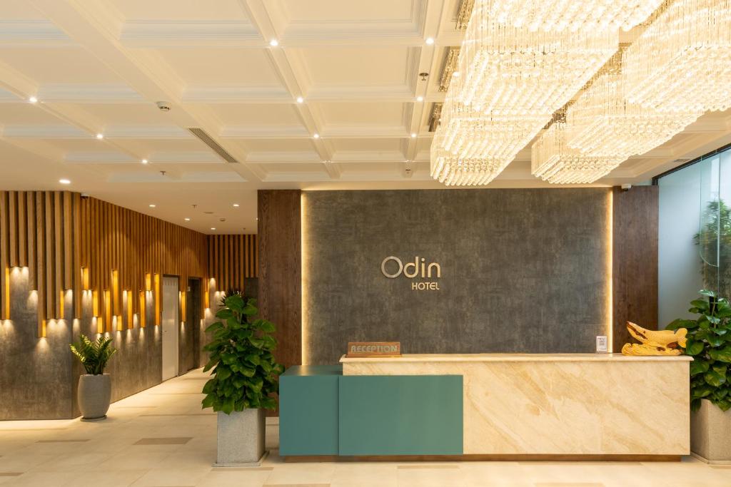 an office lobby with a reception desk and plants at Odin Hotel Quy Nhon in Quy Nhon