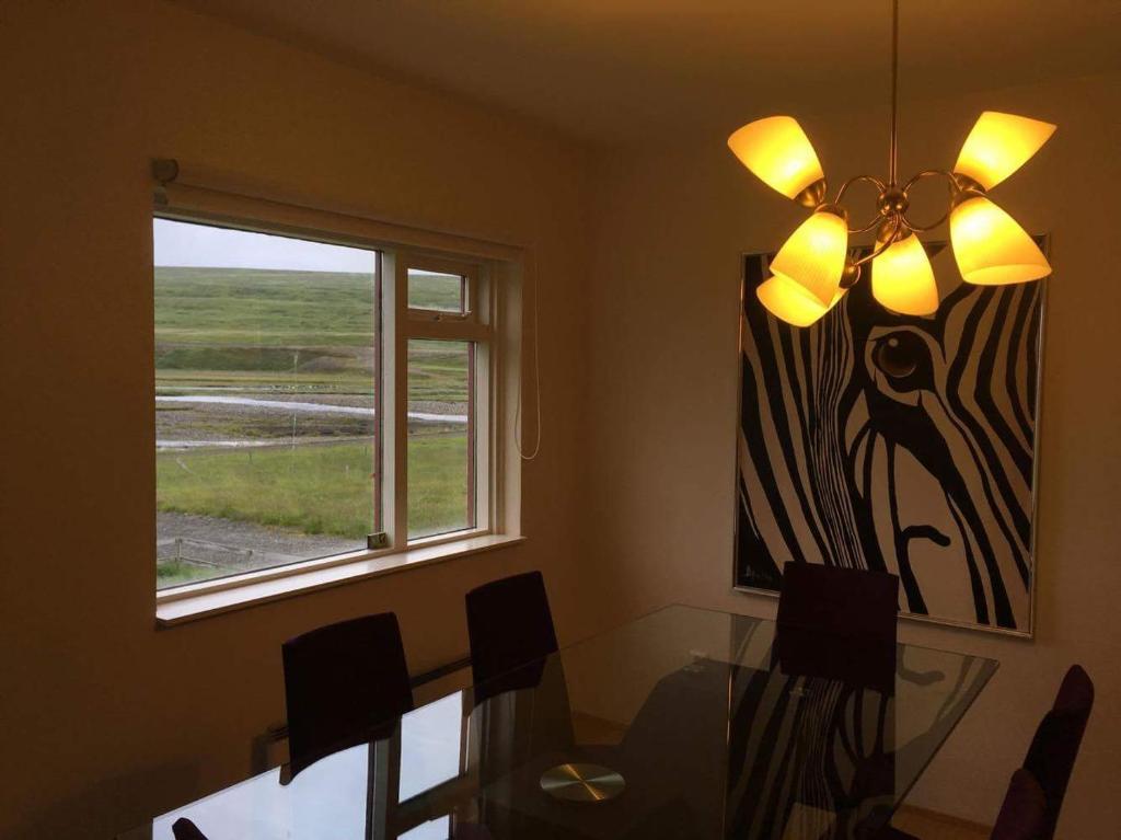 a dining room with a glass table and a window at Thorbrandsstadir Farm Holidays in Þorbrandsstaðir