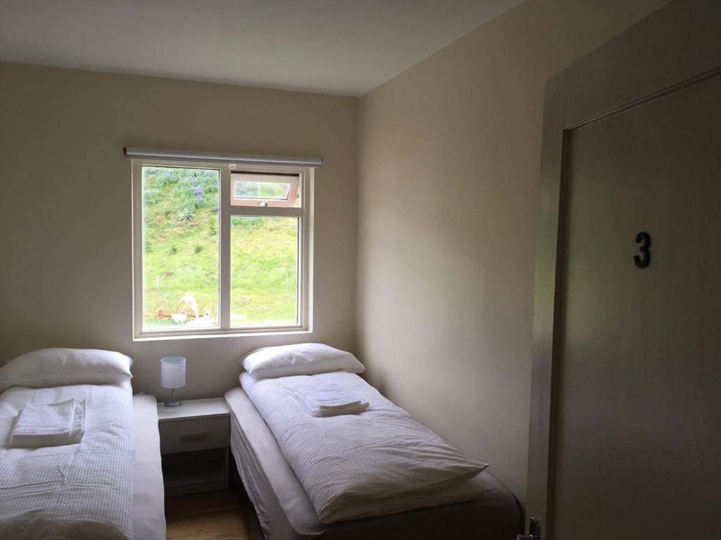 a bedroom with two beds and a window at Thorbrandsstadir Farm Holidays in Þorbrandsstaðir