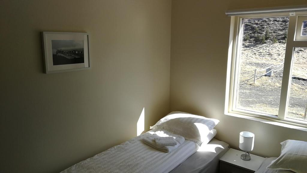 a bedroom with a bed and a window at Thorbrandsstadir Farm Holidays in Þorbrandsstaðir