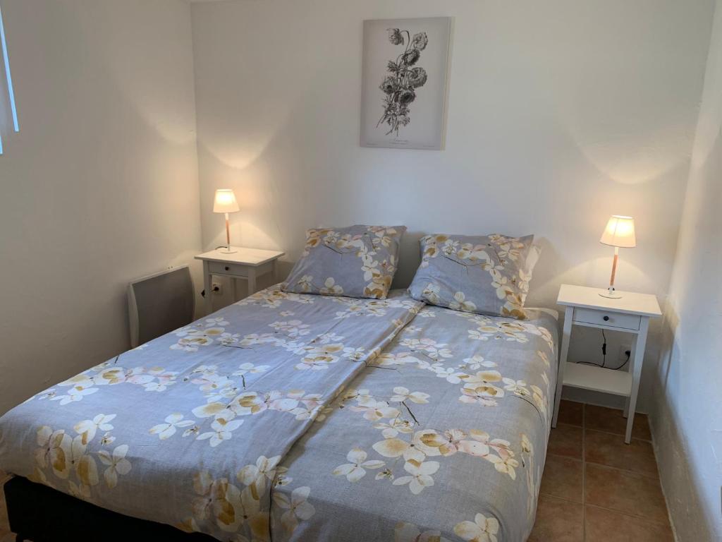 a bedroom with a bed with a blue comforter at Maison Castellane Chambre d'Hotes B&B in Castellane