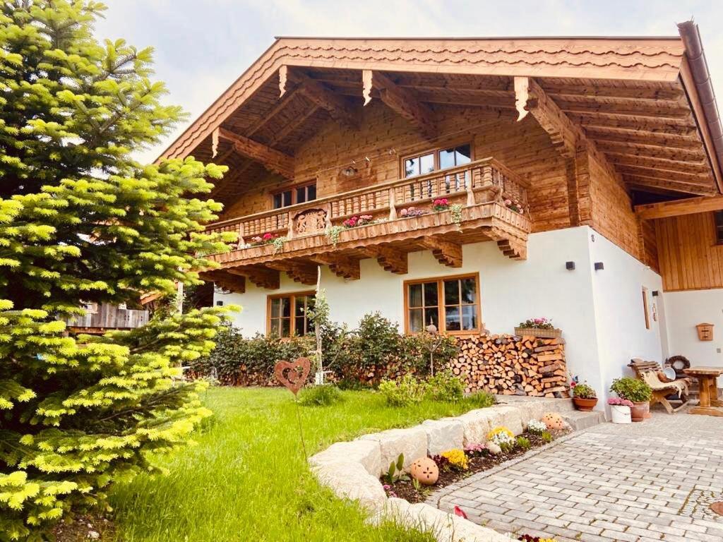 a large wooden house with a balcony in the yard at Chalet Hochgern in Staudach-Egerndach