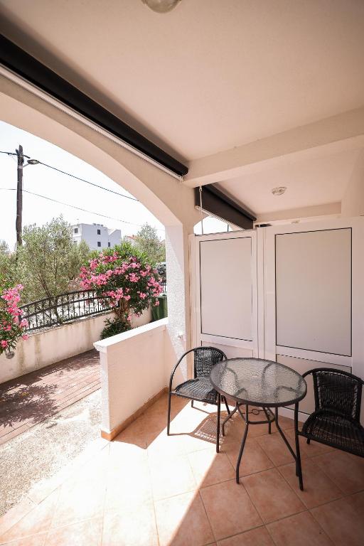 a patio with a table and chairs on a balcony at Apartments Marina in Petrcane