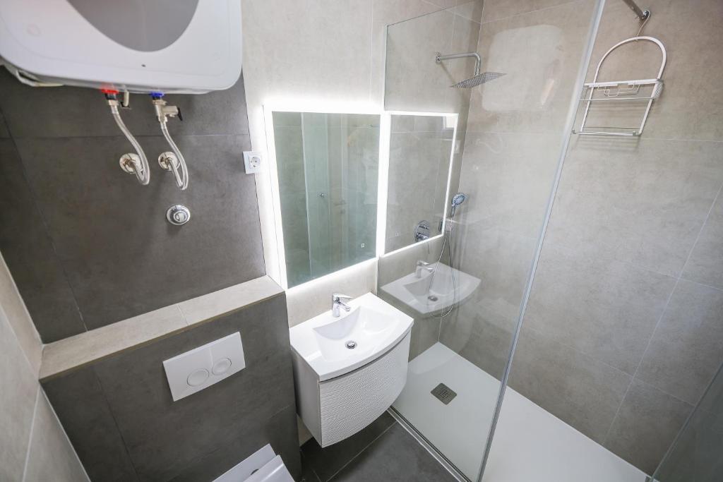 a bathroom with a toilet and a sink and a shower at Apartments Marina in Petrcane