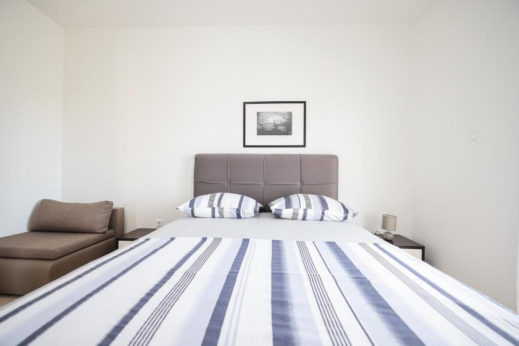 a bedroom with a bed and a chair at Apartments Marina in Petrcane
