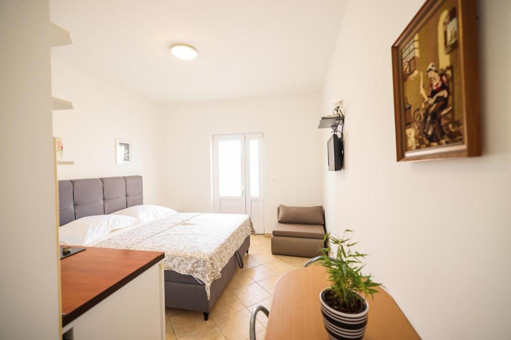a bedroom with a bed and a desk and a table at Apartments Marina in Petrcane