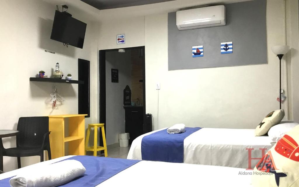 una camera d'albergo con due letti e una televisione di Hospedaje Aldana - Habitación ACUA zona centro a Tuxpan de Rodríguez Cano