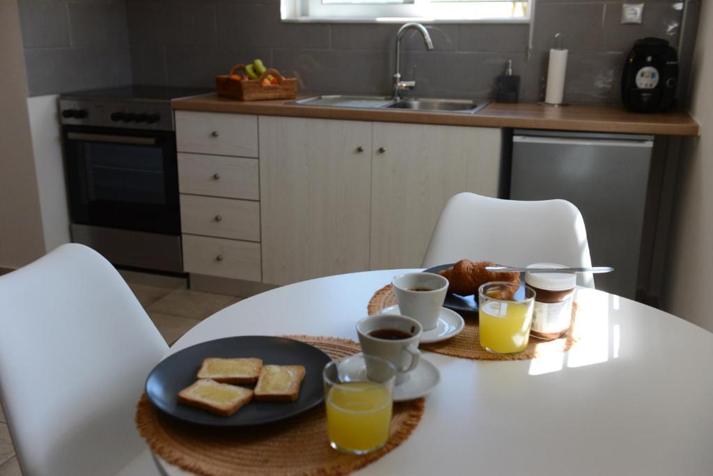 a table with a plate of food and two glasses of orange juice at Casa Raymo in Kanálion