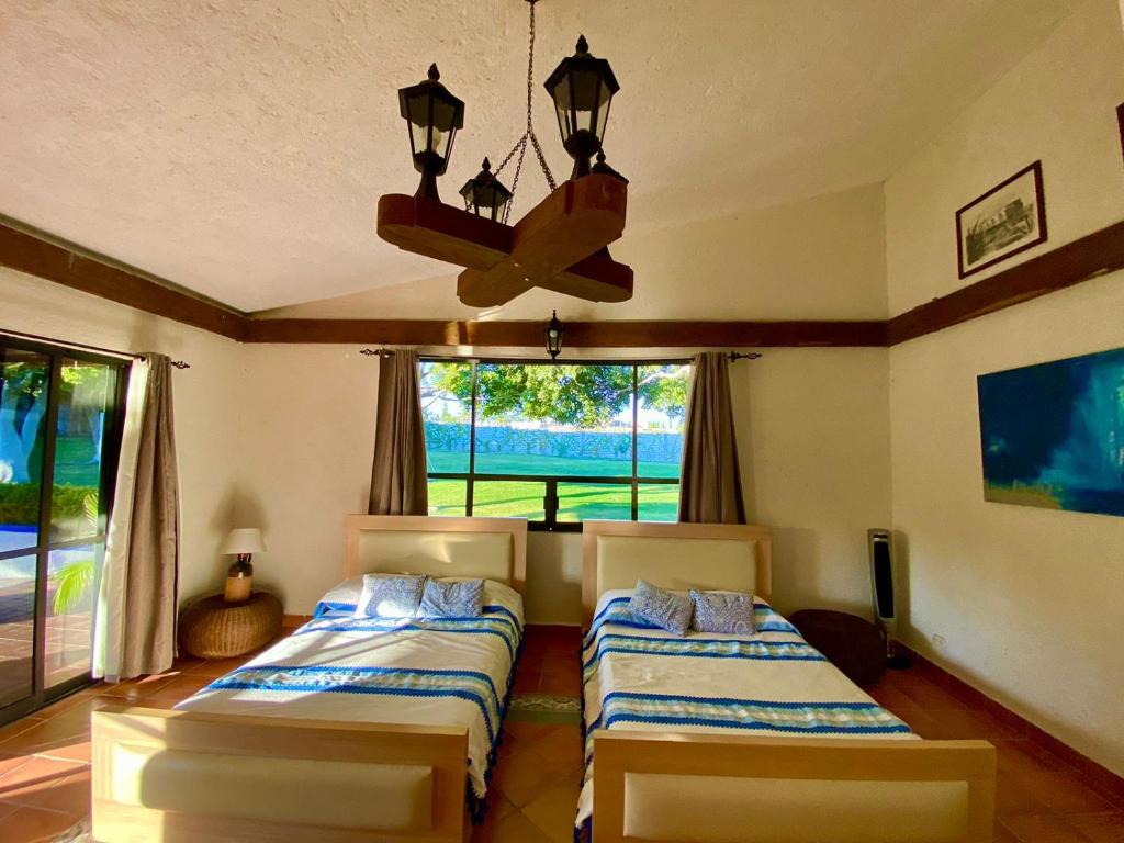 sypialnia z 2 łóżkami i żyrandolem w obiekcie La Pedrera Atlixco 