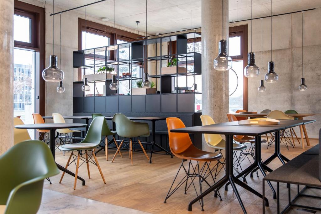 a group of tables and chairs in a restaurant at ipartment Berlin Airport in Schönefeld