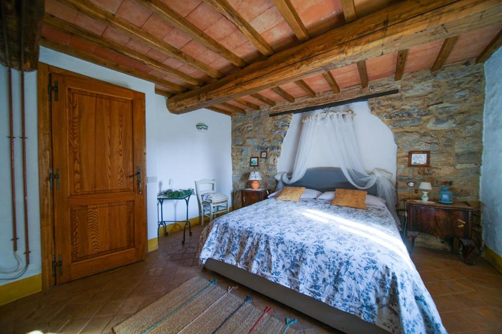 a bedroom with a bed and a stone wall at Agriturismo La Colombella in Bagni San Filippo