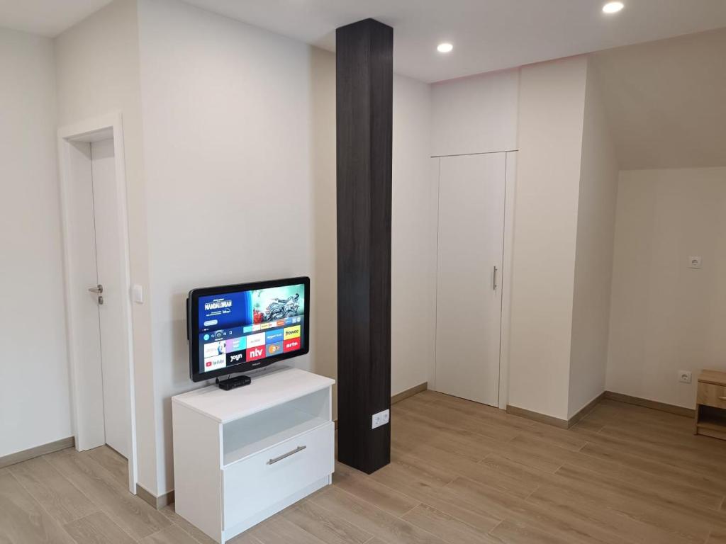 a living room with a television on a white cabinet at Appartement Design 2 in Altenstadt