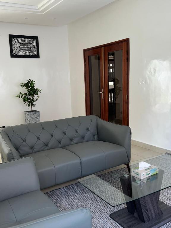 a living room with a couch and a glass table at Résidence La Renaissance de Dakar in Ouakam