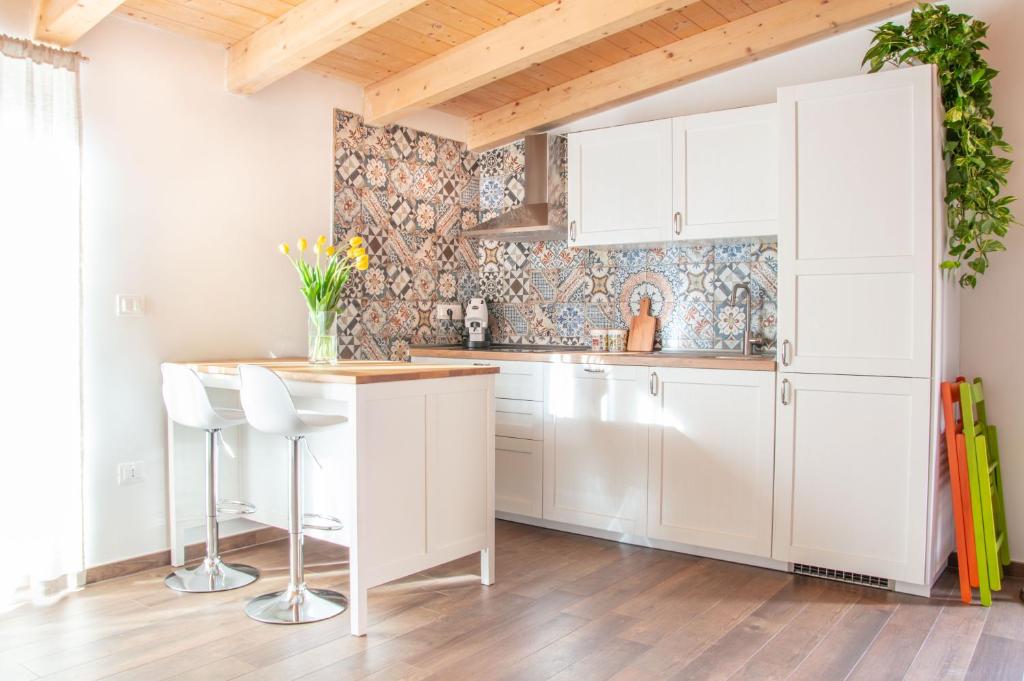 een keuken met witte kasten en een bar met bloemen bij Dépendance 6 in Salerno