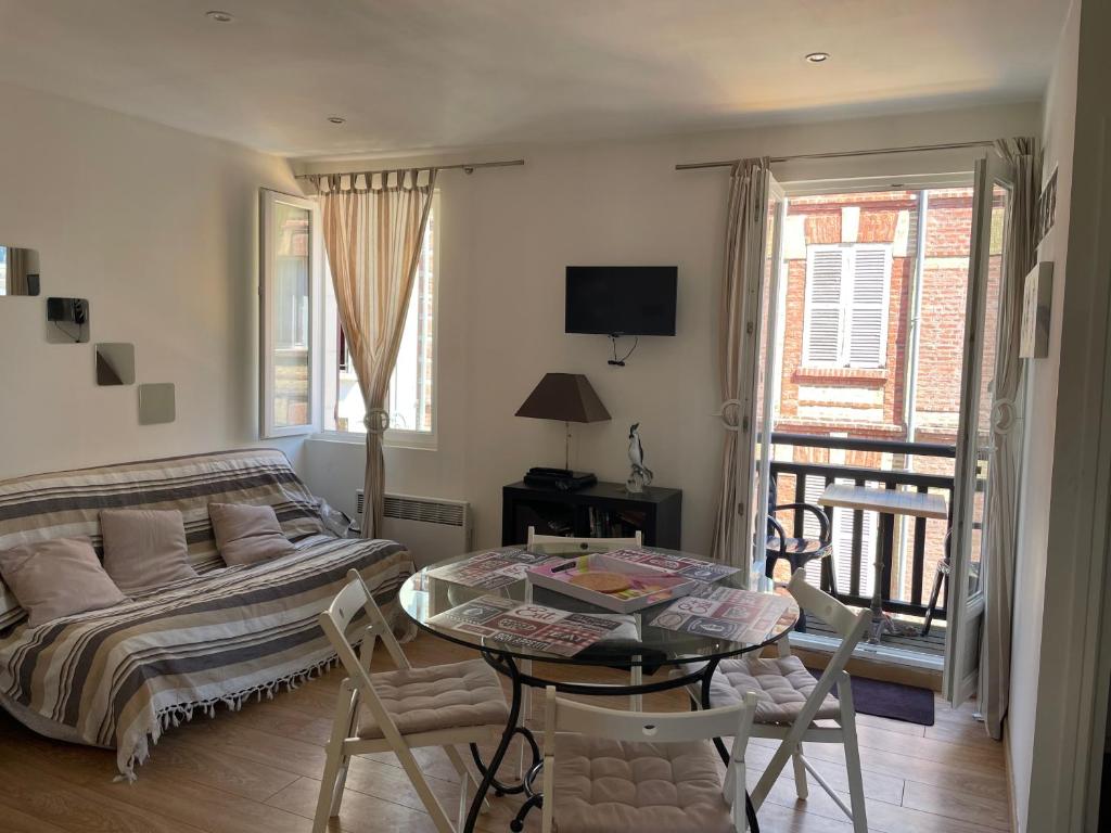 un salon avec un lit, une table et des chaises dans l'établissement Chant Marin, à Villers-sur-Mer