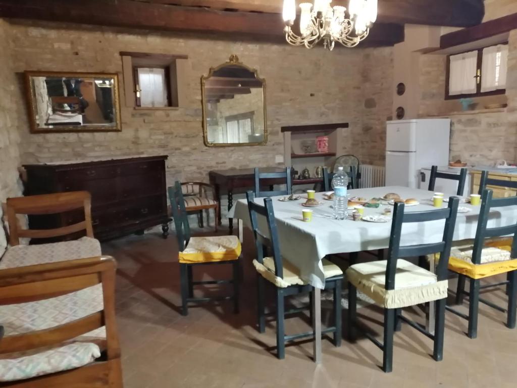 una sala da pranzo con tavolo e sedie bianchi di San Rocco Affittacamere a San Severino Marche