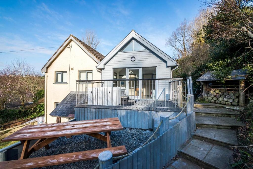a house with a wooden fence and a wooden bench at Rock Cottage - 3 Bedroom Holiday Home - Fishguard in Fishguard