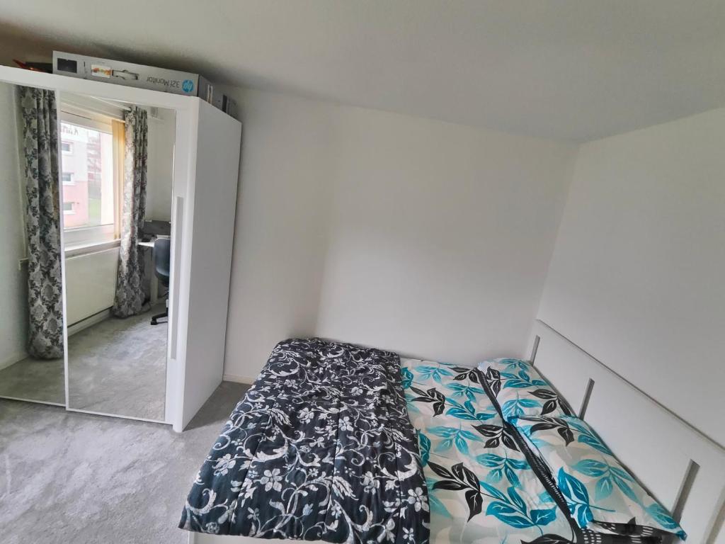 1 dormitorio con cama y espejo en The Homestay, en East Kilbride