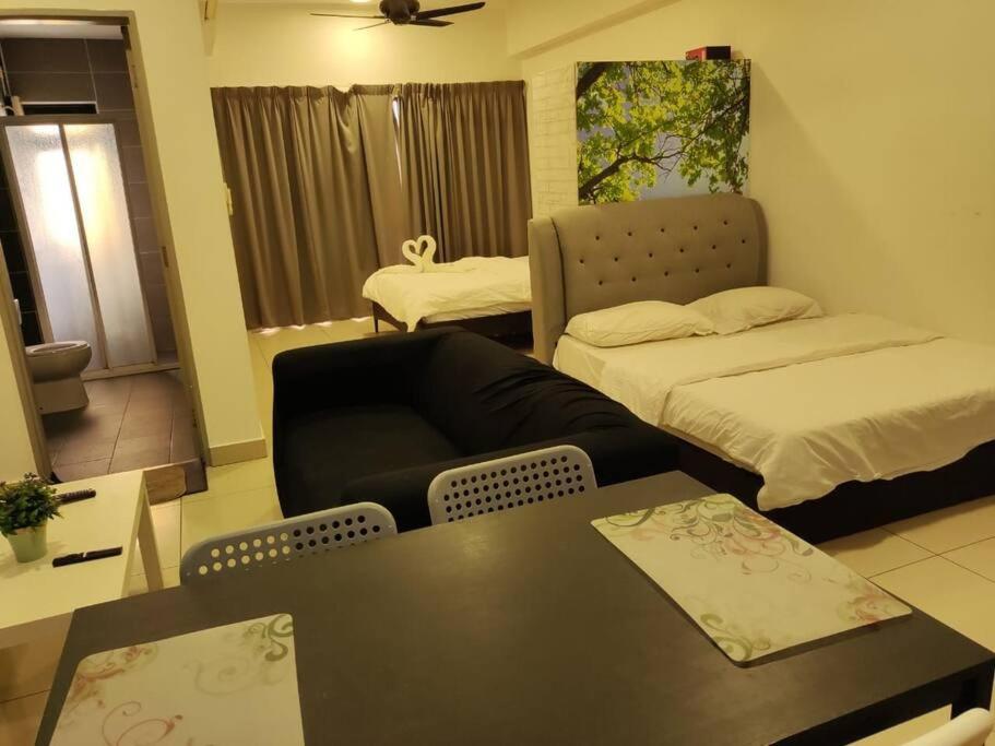 - un salon avec un canapé, un lit et une table dans l'établissement HB1516- Two queen bed-Wifi-Netflix- Parking- Cyberjaya, 3056, à Cyberjaya