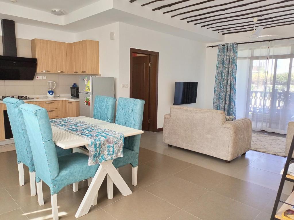 - une cuisine et une salle à manger avec une table et des chaises dans l'établissement Kikambala Luxurious Two Bedroom - Beachfront, Swimming pool View, WiFi, Smart TV, Ample Parking, 24Hr Security, à Mombasa