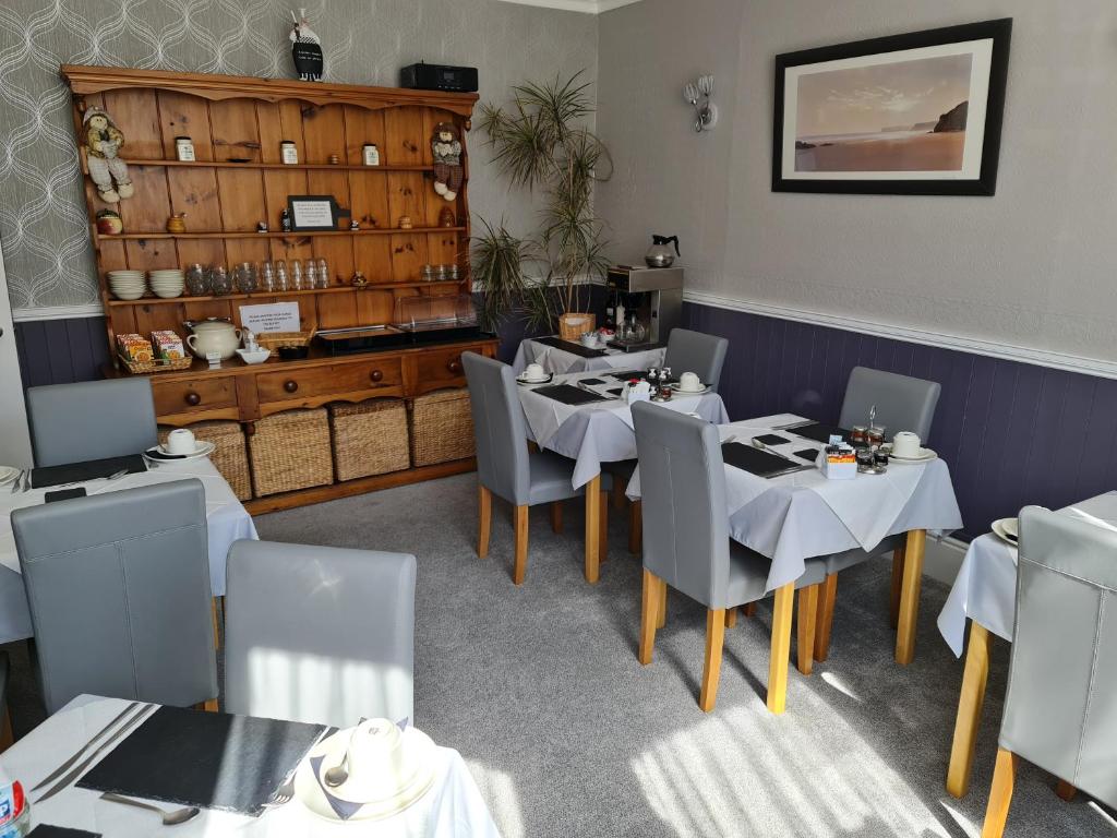 un comedor con mesas y sillas en un restaurante en Marden guest house en Weymouth