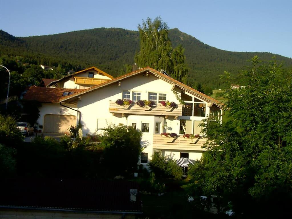 Casa blanca con balcón frente a una montaña en Ferienwohnungen Altmann Steffi und Herbert, en Lam