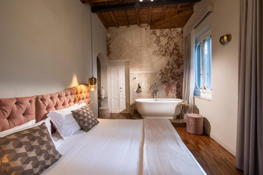 ein Schlafzimmer mit einem großen Bett und einem Waschbecken in der Unterkunft Ricasoli Garden Relais in Florenz