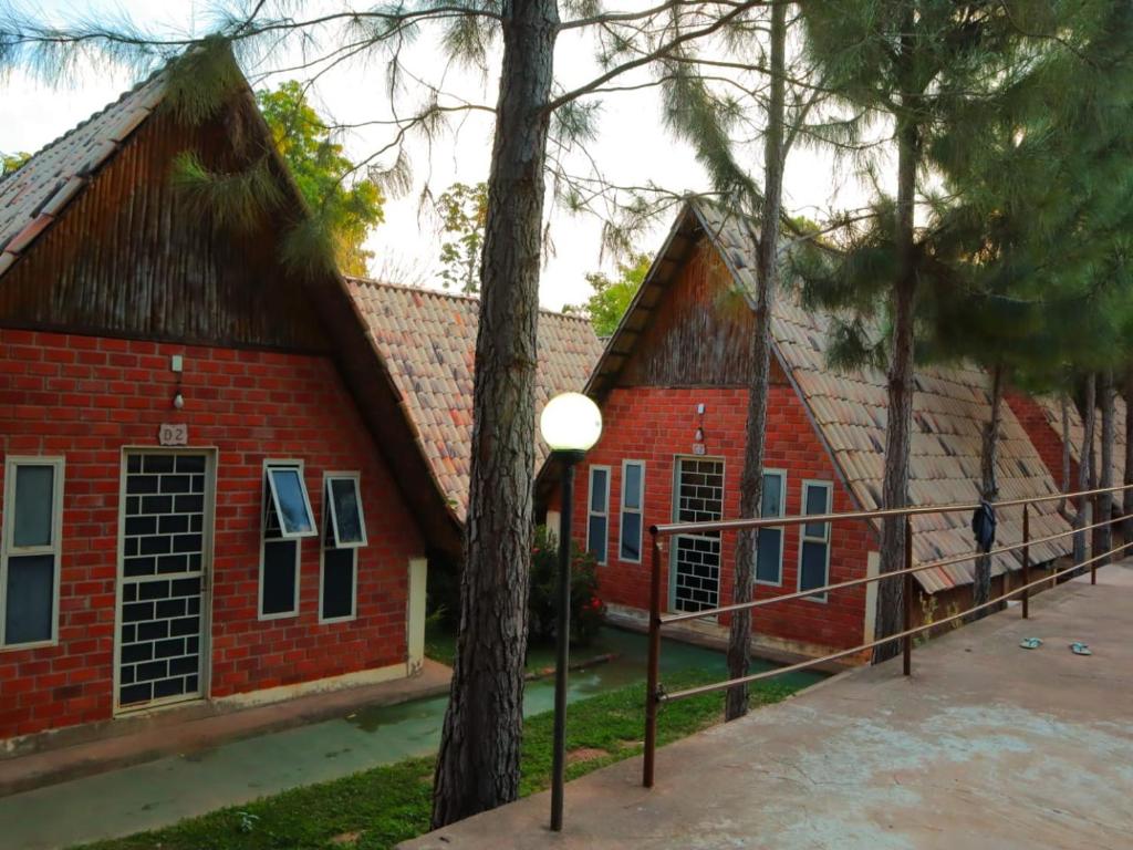 un edificio di mattoni rossi con alberi di fronte di Pousada Vereda das Aguas a Ponte Alta do Tocantins