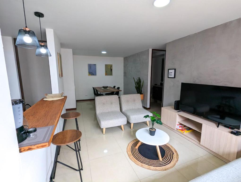 ein Wohnzimmer mit einem Sofa und einem Tisch in der Unterkunft Apartamento Completo Poblado - Ubicacion Central con Parqueadero in Medellín