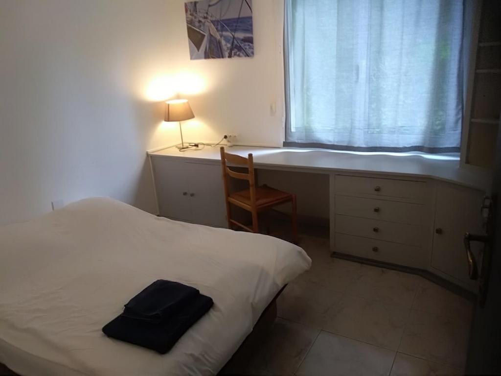 a bedroom with a bed and a desk and a window at Villa, avec piscine chauffée in Servian