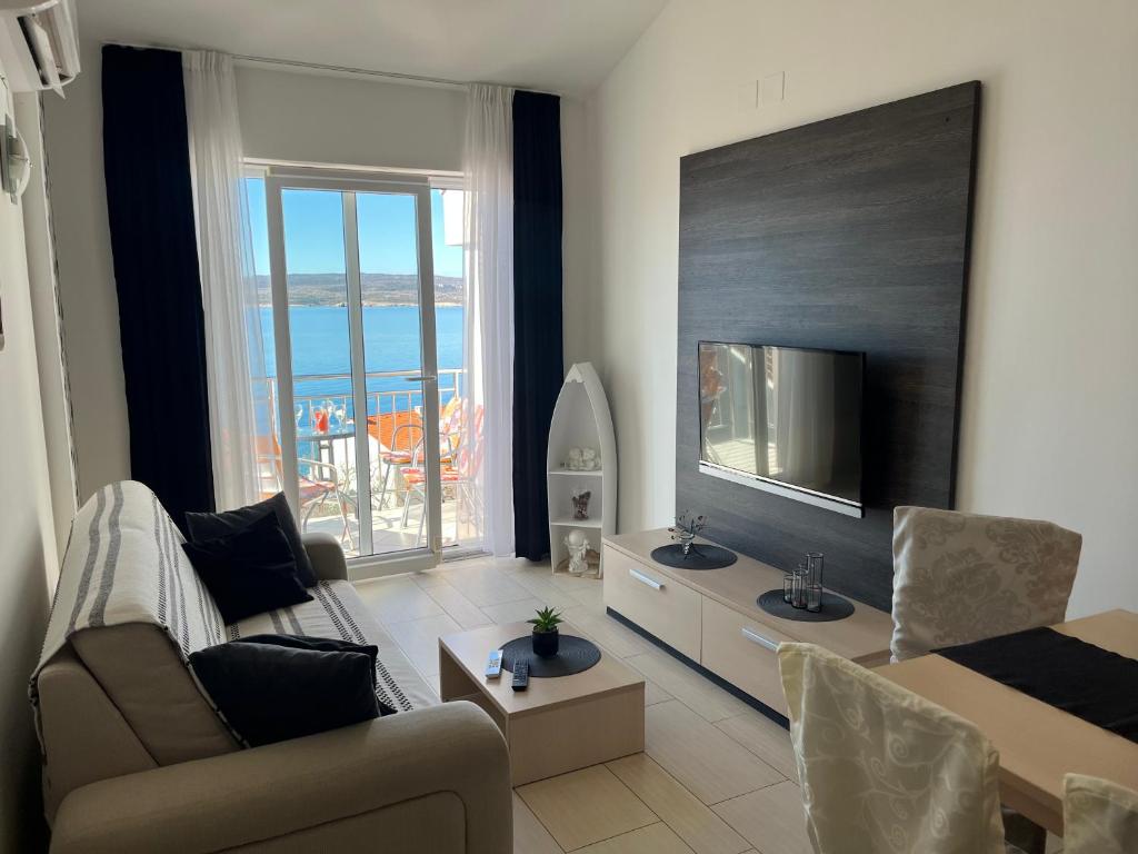 a living room with a couch and a television at Apartman Maja in Selce