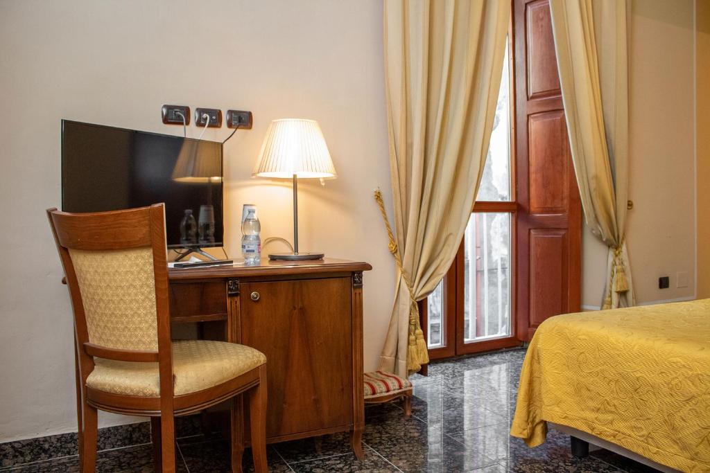 una camera con letto e scrivania con TV di Le Stanze Del Vicerè Boutique Hotel a Napoli