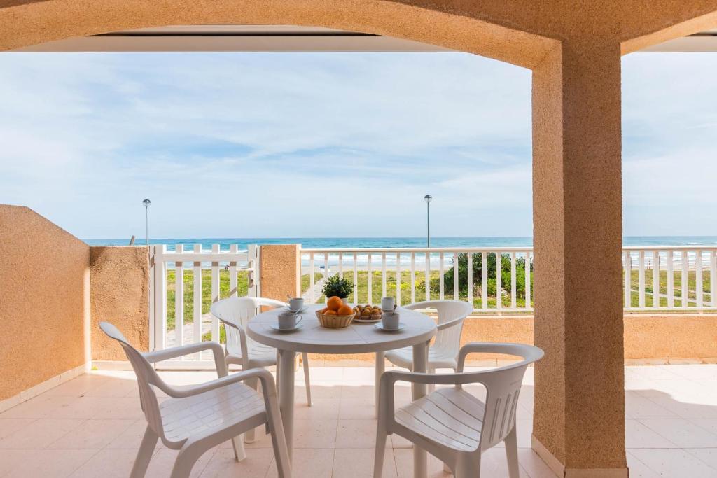 una mesa y sillas en un balcón con vistas al océano en EL RINCÓN DE FRIDA La Manga del Mar Menor KM2 Mediterráneo 2Dormitorios 2Baños, en La Manga del Mar Menor