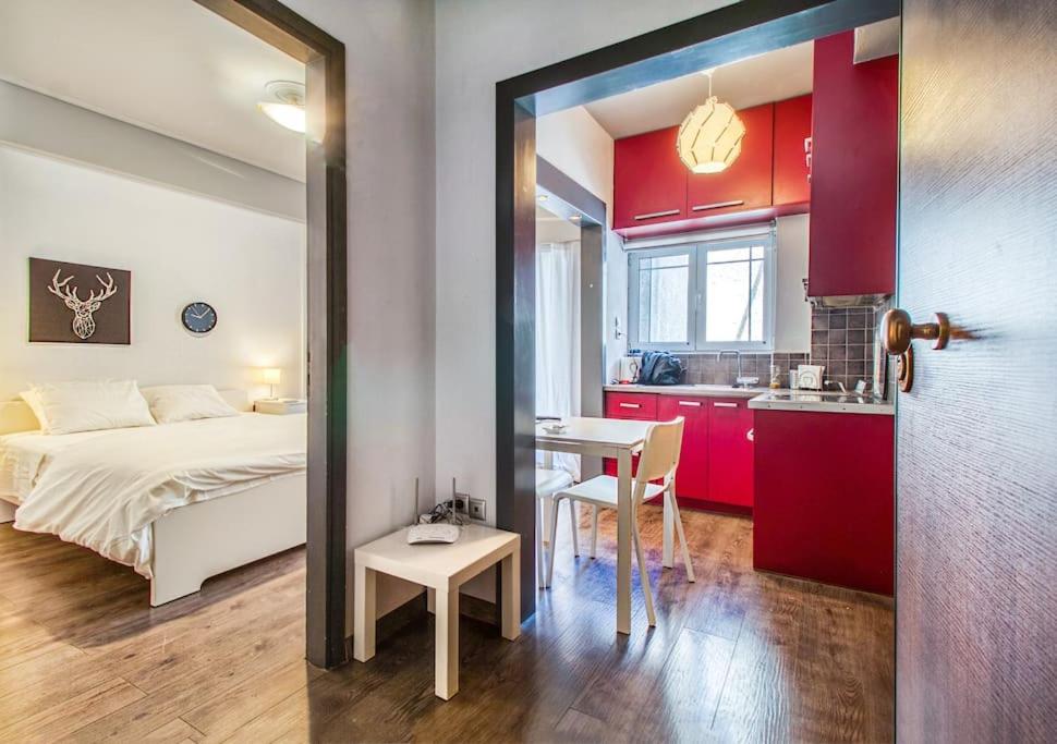 1 dormitorio con cama, mesa y cocina en Beautiful and cozy studio next to Athens center, en Atenas