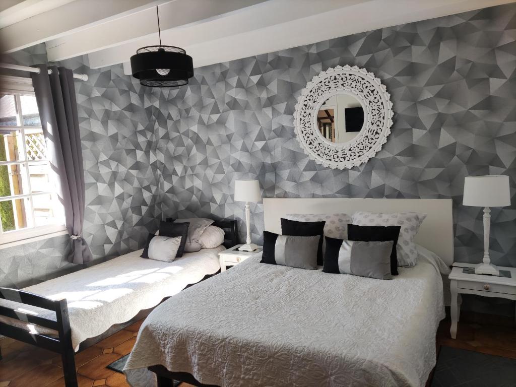- une chambre avec un lit et un miroir mural dans l'établissement Fleur De Soleil, à Saint-Jouin-Bruneval